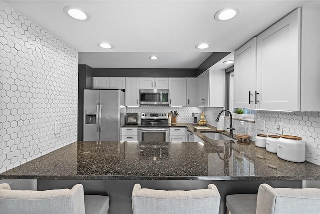 401 Olde Ingomar Ct, Mccandless, PA 15237 - kitchen with stainless steel appliances, a peninsula, dark stone countertops, backsplash, and recessed lighting