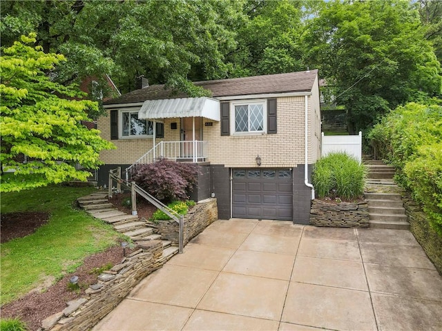 601 4th St, Penn Hills, PA 15147 - view of front of home with concrete driveway, brick siding, a garage, stairway, and roof with shingles