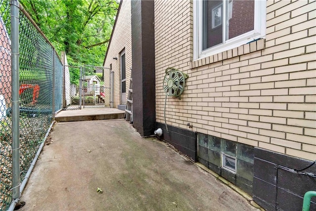 601 4th St, Penn Hills, PA 15147 - view of side of property featuring brick siding, a patio area, and a gate
