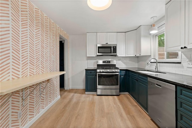 601 4th St, Penn Hills, PA 15147 - kitchen with stainless steel appliances, white cabinetry, light wood-style floors, tasteful backsplash, and dark stone counters