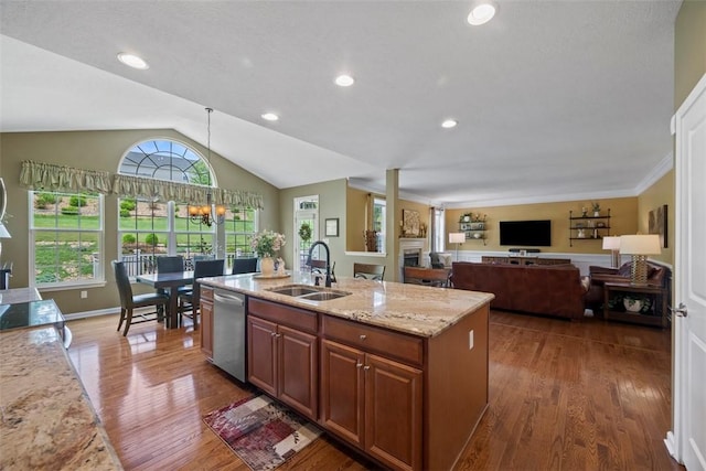 743 Packsaddle Trl, Richland, PA 15044 - kitchen with stainless steel dishwasher, wood finished floors, a center island with sink, vaulted ceiling, and light stone countertops