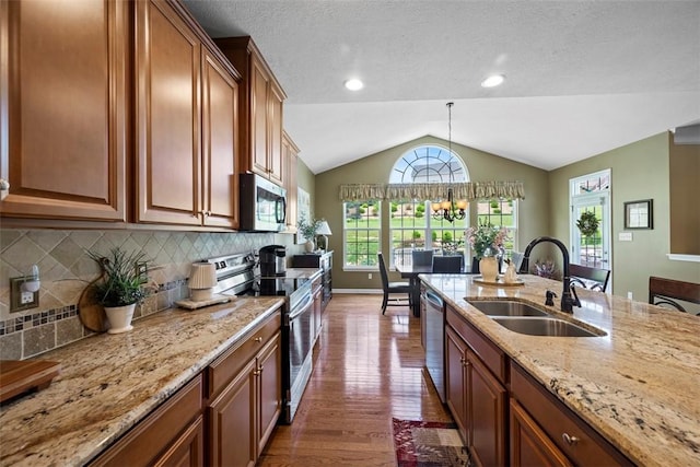 743 Packsaddle Trl, Richland, PA 15044 - kitchen featuring appliances with stainless steel finishes, vaulted ceiling, dark wood finished floors, light stone countertops, and backsplash