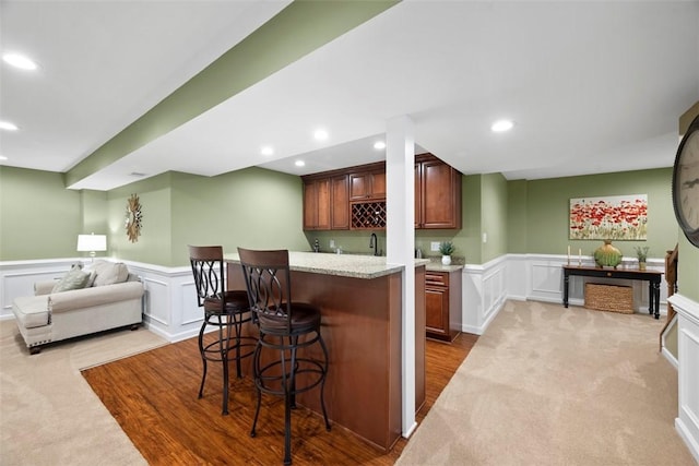 743 Packsaddle Trl, Richland, PA 15044 - kitchen with a decorative wall, a breakfast bar area, a wainscoted wall, recessed lighting, and carpet