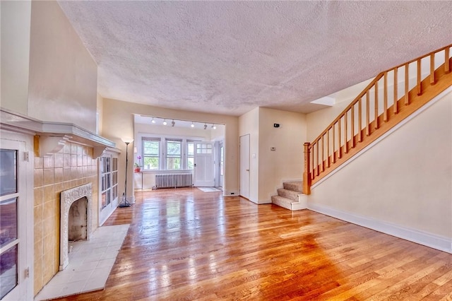 2267 Tilbury Ave, Squirrel Hill, PA 15217 - foyer featuring radiator, hardwood / wood-style flooring, a textured ceiling, stairs, and a tiled fireplace