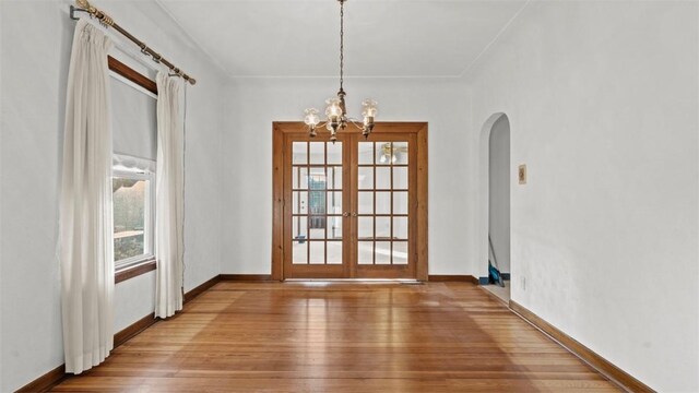 304 Wylie Ave, Elizabeth Twp/Boro, PA 15037 - unfurnished dining area with arched walkways, wood finished floors, a chandelier, and french doors