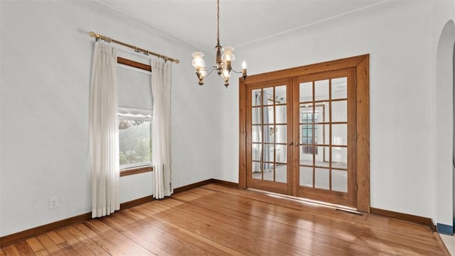 304 Wylie Ave, Elizabeth Twp/Boro, PA 15037 - unfurnished dining area with french doors, a chandelier, hardwood / wood-style flooring, and arched walkways