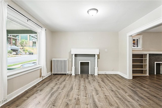 1334 Franklin Ave, Wilkinsburg, PA 15221 - unfurnished living room featuring radiator heating unit, a fireplace, and wood finished floors