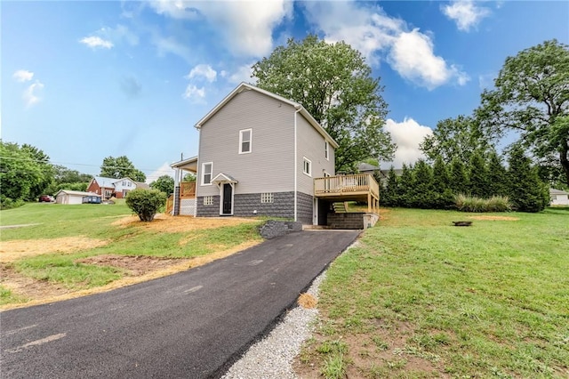 1451 W Pittsburgh St, East Huntingdon, PA 15683 - view of property exterior featuring a lawn, a wooden deck, and asphalt driveway