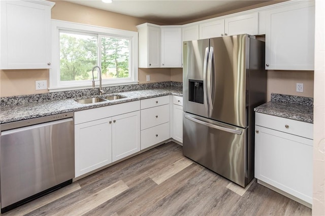 1451 W Pittsburgh St, East Huntingdon, PA 15683 - kitchen featuring stainless steel appliances, light wood-style floors, white cabinetry, and light stone counters