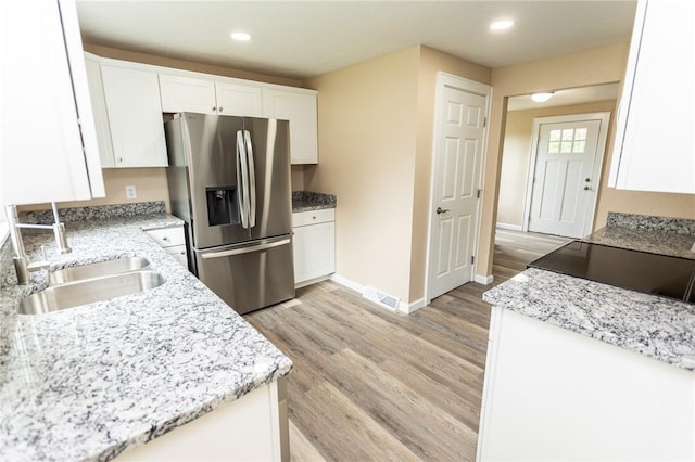 1451 W Pittsburgh St, East Huntingdon, PA 15683 - kitchen with stainless steel refrigerator with ice dispenser, light wood finished floors, white cabinets, recessed lighting, and light stone countertops
