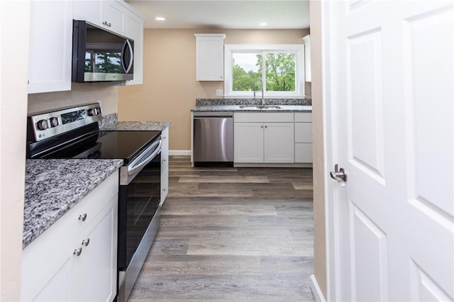 1451 W Pittsburgh St, East Huntingdon, PA 15683 - kitchen with appliances with stainless steel finishes, wood finished floors, white cabinets, light stone counters, and recessed lighting