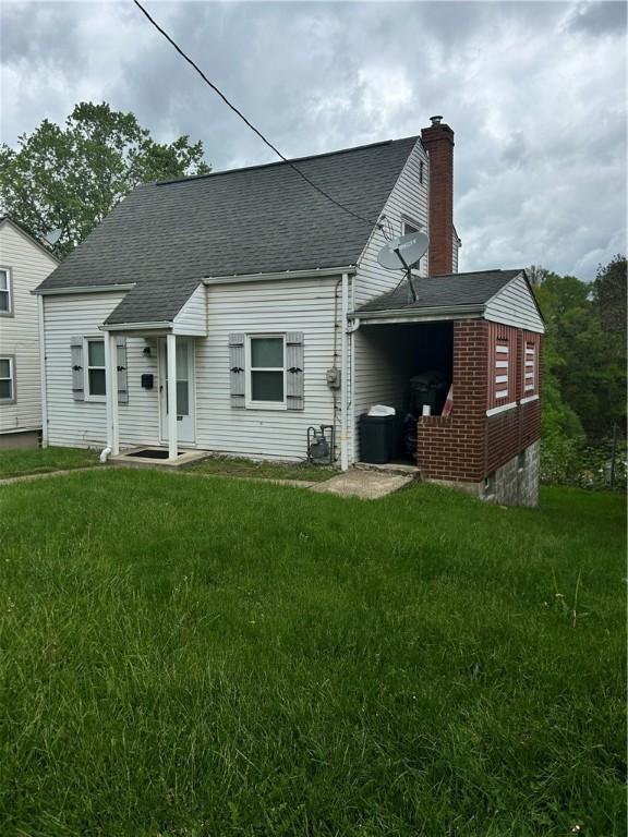 1055 Laurel St, Bridgeville, PA 15017 - back of house featuring a shingled roof, a yard, and a chimney