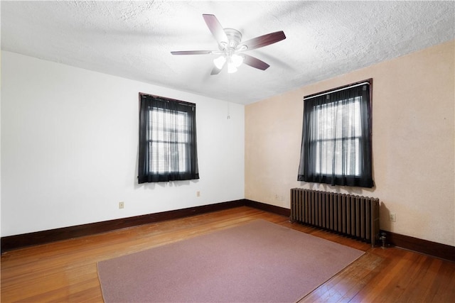 512 Gorgas St, Arlington, PA 15210 - empty room featuring radiator, hardwood / wood-style flooring, healthy amount of natural light, ceiling fan, and a textured ceiling