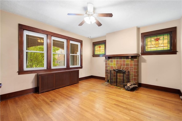 512 Gorgas St, Arlington, PA 15210 - unfurnished living room with radiator, light wood-type flooring, a fireplace, and a ceiling fan