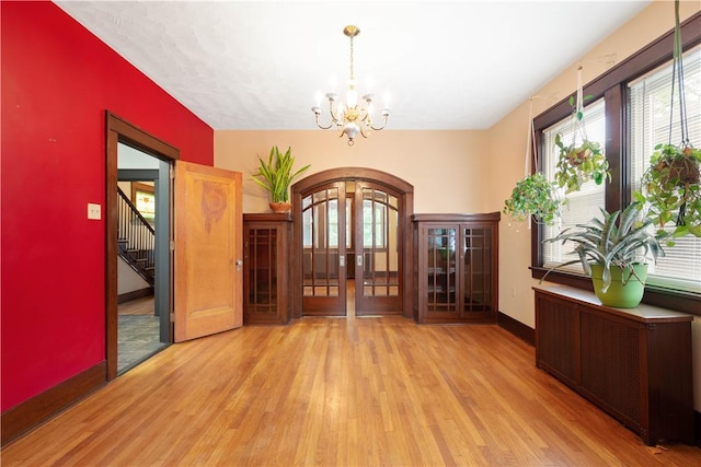 512 Gorgas St, Arlington, PA 15210 - foyer entrance featuring wood finished floors, a chandelier, arched walkways, french doors, and stairs