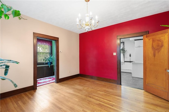 512 Gorgas St, Arlington, PA 15210 - empty room with light wood-style flooring, a chandelier, and a baseboard heating unit