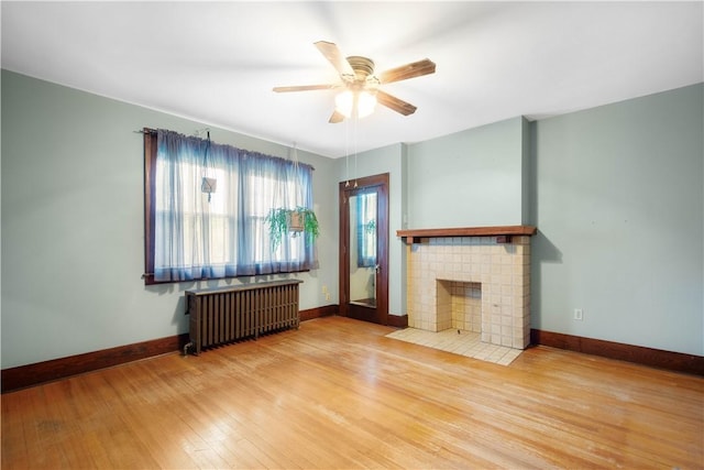 512 Gorgas St, Arlington, PA 15210 - unfurnished living room with radiator heating unit, wood finished floors, ceiling fan, and a fireplace