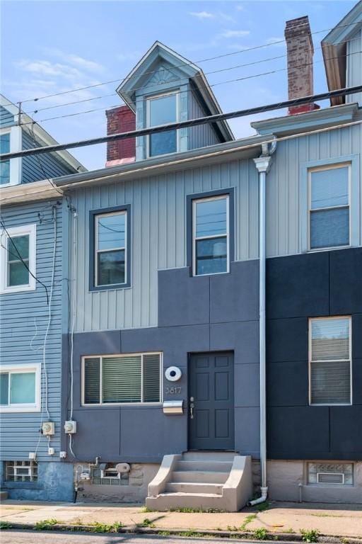 3817 Howley St, Lawrenceville, PA 15201 - townhome / multi-family property with a chimney, entry steps, and board and batten siding