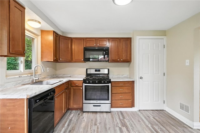 1114 Ellopia St, Chartiers City, PA 15204 - kitchen with black appliances, light wood-type flooring, light countertops, and brown cabinets