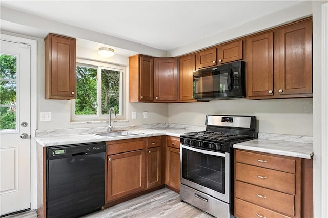 1114 Ellopia St, Chartiers City, PA 15204 - kitchen featuring black appliances, light countertops, light wood-type flooring, and brown cabinets