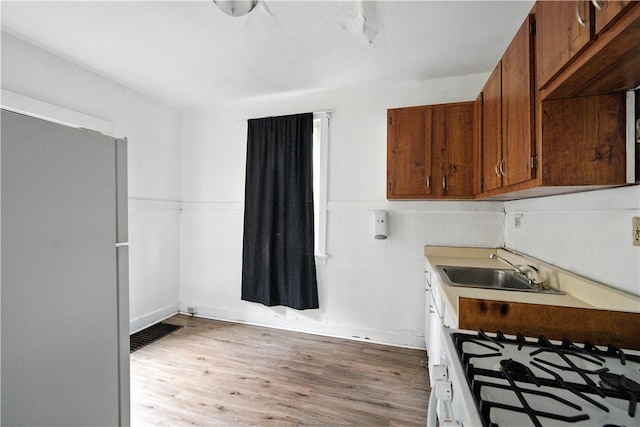 2505 Gable St, South Side, PA 15210 - kitchen with light wood-style flooring, brown cabinetry, light countertops, and stove
