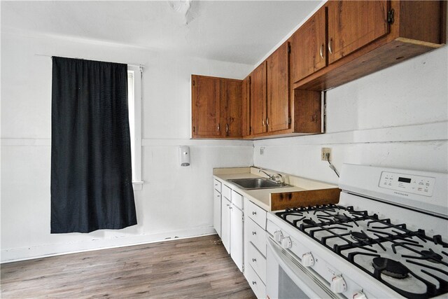 2505 Gable St, South Side, PA 15210 - kitchen with white gas range, wood finished floors, light countertops, and brown cabinetry