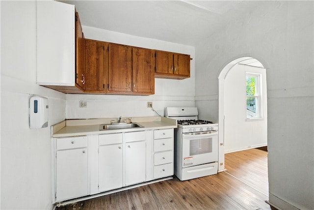 2505 Gable St, South Side, PA 15210 - kitchen with gas range gas stove, light countertops, light wood-type flooring, and white cabinets