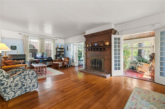 6517 Aylesboro Ave, Squirrel Hill, PA 15217 - living room featuring wood finished floors, a brick fireplace, and plenty of natural light