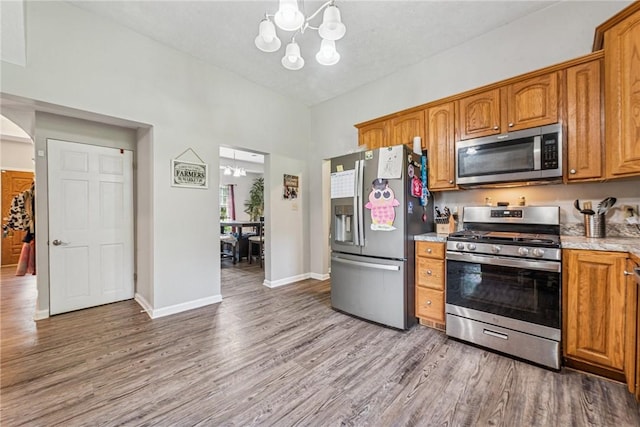 27 Richeyville Rd, Centerville, PA 15358 - kitchen featuring appliances with stainless steel finishes, a chandelier, light wood-type flooring, and brown cabinets
