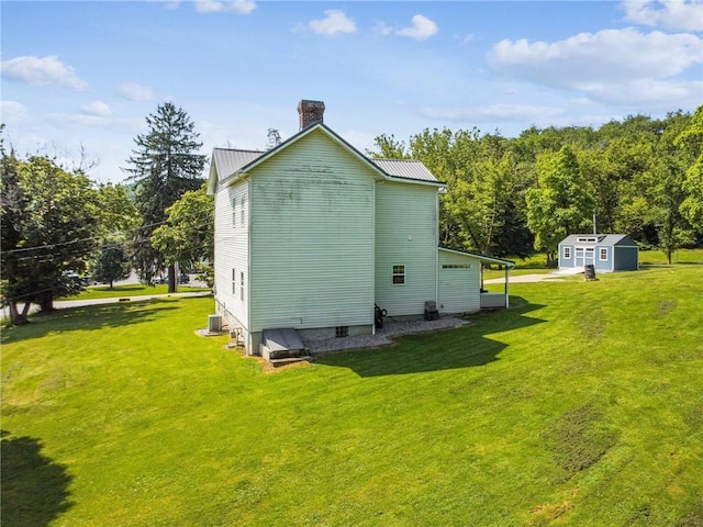 27 Richeyville Rd, Centerville, PA 15358 - view of side of home featuring a chimney, a shed, a lawn, and a metal roof