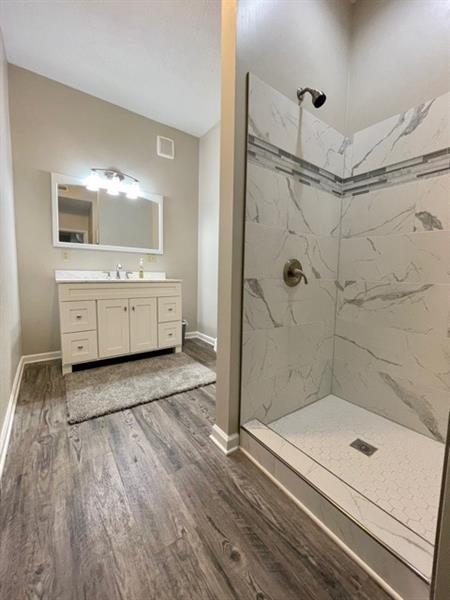 27 Richeyville Rd, Centerville, PA 15358 - bathroom featuring a marble finish shower, wood finished floors, and vanity