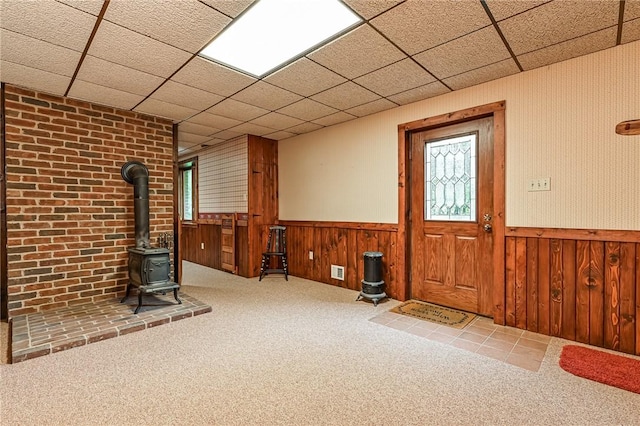 117 Oak Dr, Forward Twp But, PA 16033 - carpeted foyer with a wood stove, wainscoting, a paneled ceiling, and wooden walls