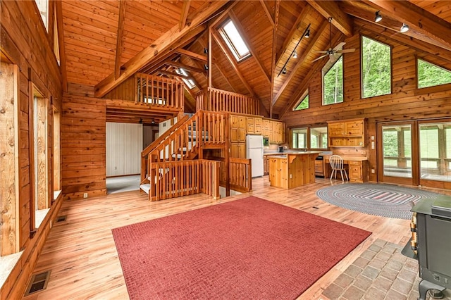 117 Oak Dr, Forward Twp But, PA 16033 - living area with high vaulted ceiling, wooden walls, light wood finished floors, stairway, and a wood ceiling with exposed beams