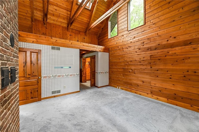 117 Oak Dr, Forward Twp But, PA 16033 - unfurnished living room featuring a wood ceiling with exposed beams, carpet floors, wood walls, high vaulted ceiling, and a skylight