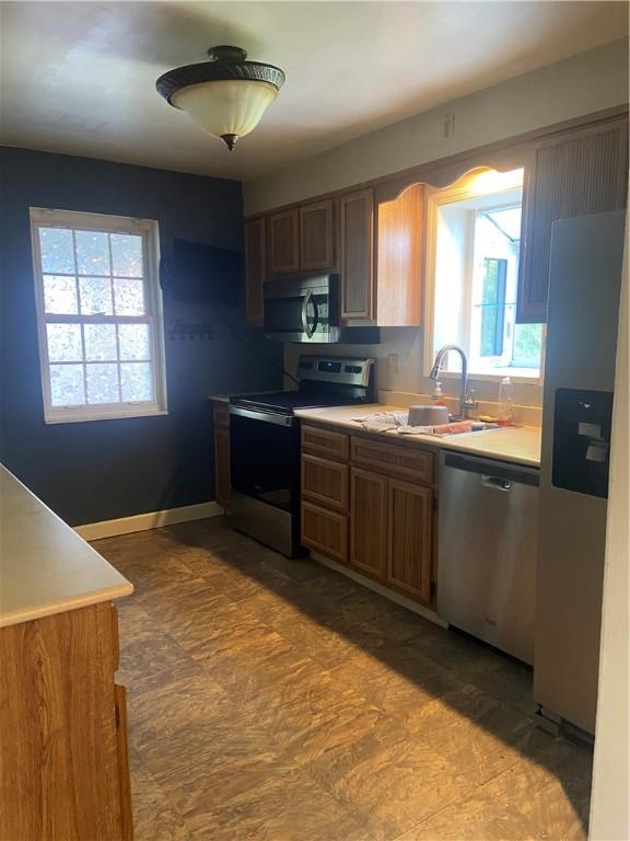 175 Crescent Hills Rd, Penn Hills, PA 15235 - kitchen with appliances with stainless steel finishes, light countertops, and brown cabinets
