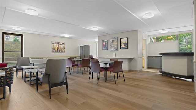 220 N Dithridge St Unit 1001, Oakland, PA 15213 - dining space featuring light wood-type flooring, healthy amount of natural light, a bar, and a wall mounted air conditioner