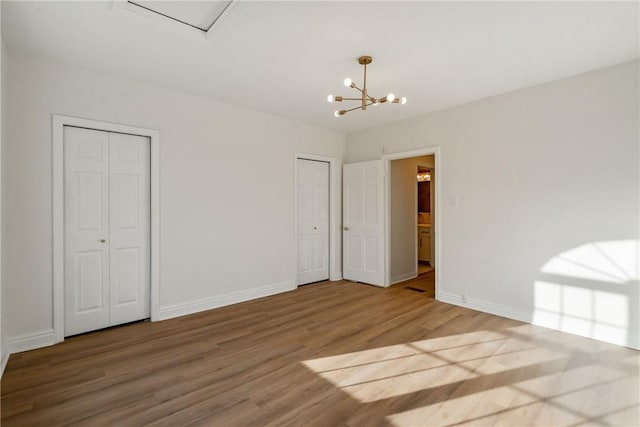 516 Division Ave, Bellevue, PA 15202 - unfurnished bedroom featuring multiple closets, wood finished floors, and a chandelier