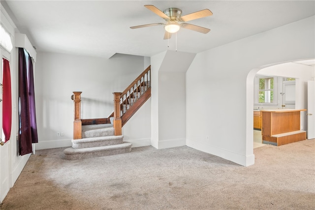 97 N Euclid Ave, Bellevue, PA 15202 - unfurnished living room with light colored carpet, a ceiling fan, arched walkways, and stairs