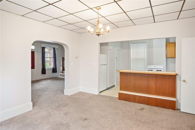 97 N Euclid Ave, Bellevue, PA 15202 - kitchen with arched walkways, light colored carpet, freestanding refrigerator, a chandelier, and a paneled ceiling