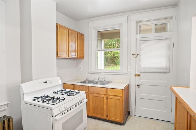 97 N Euclid Ave, Bellevue, PA 15202 - kitchen with white range with gas stovetop, light countertops, radiator heating unit, and brown cabinetry