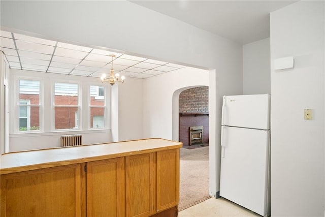 97 N Euclid Ave, Bellevue, PA 15202 - kitchen with freestanding refrigerator, arched walkways, radiator heating unit, light countertops, and decorative light fixtures