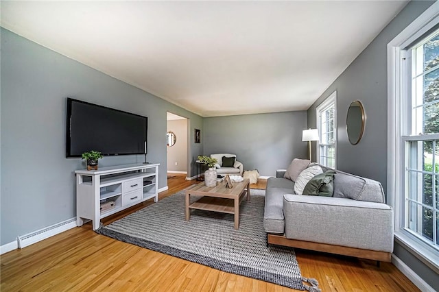 150 Dover Dr, Moon/Crescent Twp, PA 15108 - living room featuring a baseboard heating unit, wood finished floors, and healthy amount of natural light