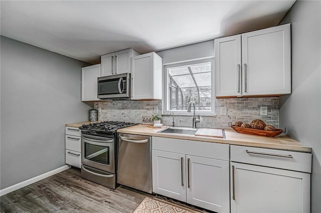 150 Dover Dr, Moon/Crescent Twp, PA 15108 - kitchen featuring appliances with stainless steel finishes, wood finished floors, light countertops, and backsplash
