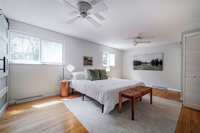 150 Dover Dr, Moon/Crescent Twp, PA 15108 - bedroom featuring a baseboard heating unit, light wood-style flooring, and ceiling fan