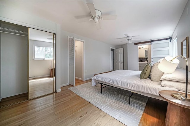 150 Dover Dr, Moon/Crescent Twp, PA 15108 - bedroom featuring light wood-type flooring, a barn door, a ceiling fan, and ensuite bath