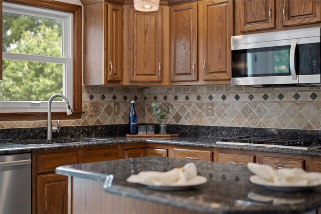 105 Averys Way, Cranberry Twp, PA 16066 - kitchen featuring appliances with stainless steel finishes, brown cabinetry, tasteful backsplash, and dark stone counters