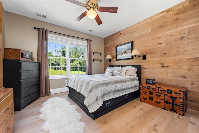 548 Lang Rd, Sewickley Heights, PA 15143 - bedroom featuring wooden walls, light wood-style flooring, and a ceiling fan