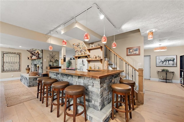 548 Lang Rd, Sewickley Heights, PA 15143 - indoor bar with light wood finished floors, refrigerator, stairway, decorative light fixtures, and track lighting