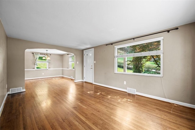 345 Franklin Dr, Peters Twp, PA 15241 - unfurnished living room with arched walkways, a chandelier, and wood finished floors