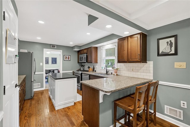 130 Kent Dr, Upper St Clair, PA 15241 - kitchen with appliances with stainless steel finishes, a kitchen island, backsplash, light wood-style floors, and recessed lighting